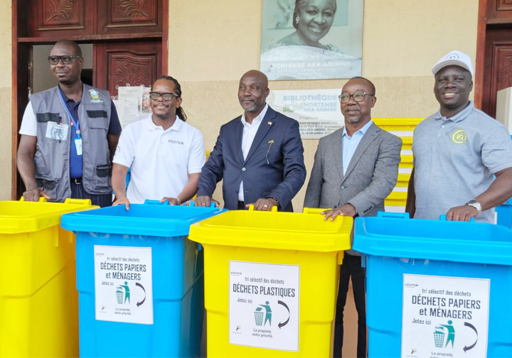 Intertek colleagues and local officials stand behind donated recycling bins. 