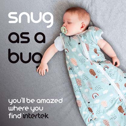 A baby sleeping on a bed wrapped in a cloth snuggle blanket